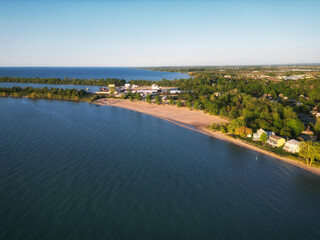 Aerial drone view of the popular recreational area, Sunset Beach. Located off the Welland Canal in Lake Ontario, St. Catharines, Ontario, Canada. Shot during a spring afternoon, May, 2023.