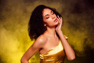 Photo of dreamy adorable lady wear gold dress close eyes touch cheek isolated yellow light...