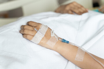 Intravenous saline. Sick People, Close up of hand are lying and being treated in beds in hospitals.