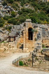 The entrance to the semicircular, adjacent to the rock, ancient Roman theater on the plateau in Demre in Turkey