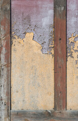 Detail of a half-timbered house with a layer of purple and yellow paint