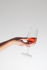 A hand holding a glass with rose wine	