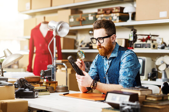 Young business owner checking vintage items in his shop