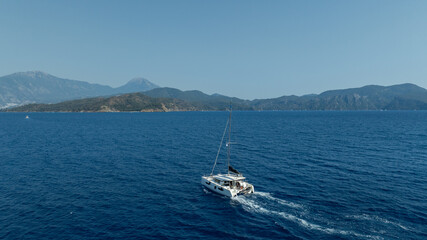  catamaran sailing gracefully, captured by a drone.