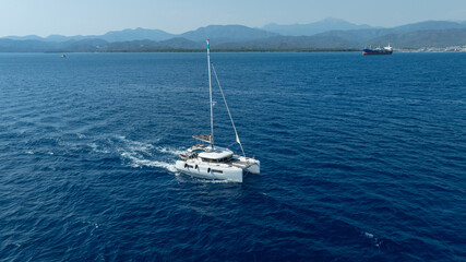 Fototapeta premium catamaran sailing gracefully, captured by a drone.