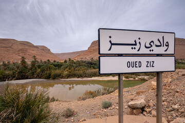 Ziz River signpost in front of the impressive oasis in the Ziz River valley, located in the Middle Atlas region in Morocco, North Africa