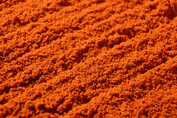 Ground paprika, red terracotta spice background, art in cooking.