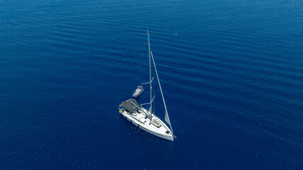 Stunning drone shot of a sailing boat gliding under the clear blue sky