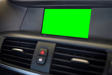 Monitor in car isolated blank screen for navigation maps and GPS rearview camera and parking assistant. Car display with blank green screen for design mock up, copy space.