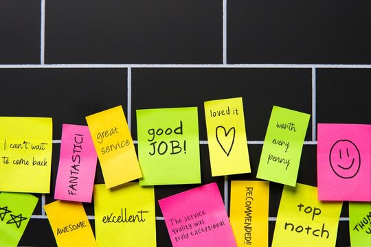 A colorful sticky notes with positive and encouraging messages displayed on a wall. Customer experience, feedback and satisfaction concept.