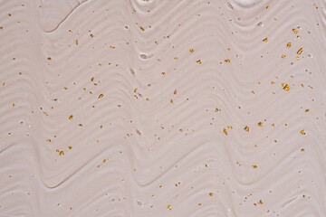 Obraz premium Liquid gel abstract cosmetic background. Smear of transparent moisturizing product with golden particles on beige background