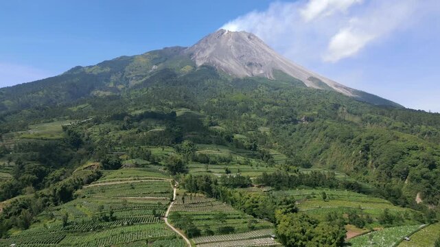 Aerial view of the active Merapi volcano and picturesque agricultural farmland on its slopes in Indonesia