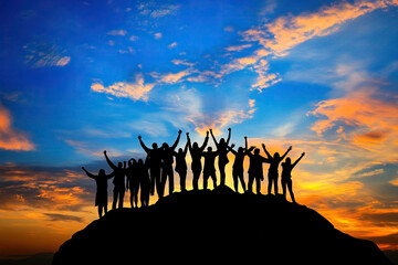 Silhouettes of group people men and women standing in celebration their victory at sunset