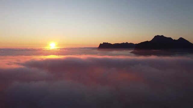 Dreamy aerial view over clouds with midnight sun in Lofoten, Northern Norway