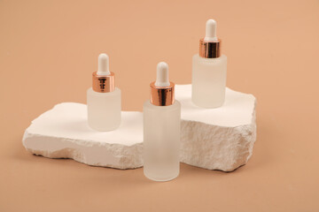 Frosted Glass Dropper Bottles on Stone and Wood Elements