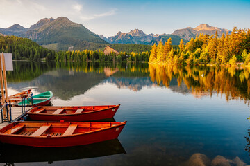 Obraz premium Red boats on Mountain lake Strbske pleso. Strbske lake with view of the High Tatras National Park, Slovakia