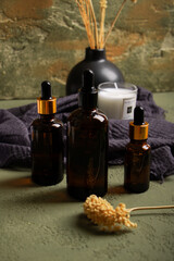 Naklejka premium Amber Dropper Bottle with Dried Flowers and Candle