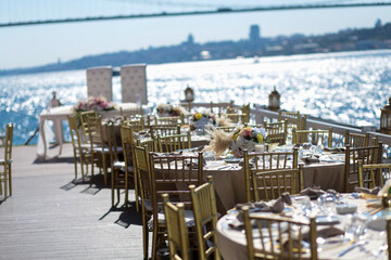 A stunning wedding reception overlooking the Bosphorus with gold chairs and floral centerpieces