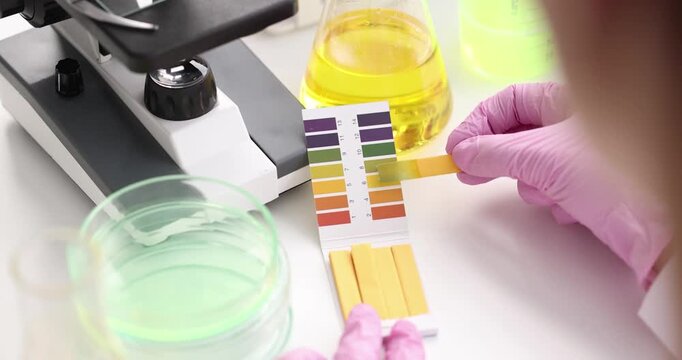 Chemist in lab checking with ph strips. Biologist checks chemical alkaline analysis in laboratory concept