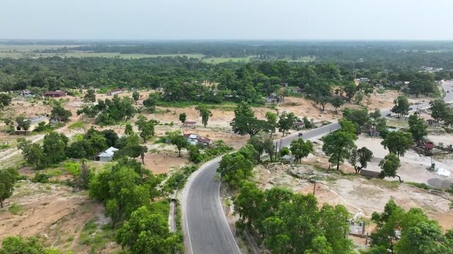 Aerial View of Serene Countryside with Winding Road and Lush Greenery