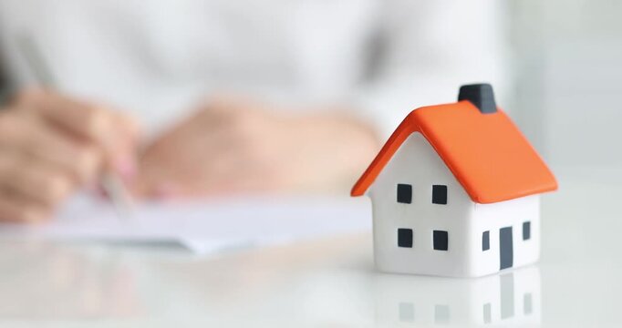 Woman signing a mortgage or insurance contract. Act of sale and purchase when buying new home or selling. Real estate probate