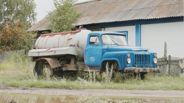 An old sewage disposal machine standing on the side of the road next to the house. The GAZ car of Soviet times. A rarity of the USSR.