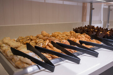 Freshly baked pastry goods on display in a breakfast buffet in a hotel
