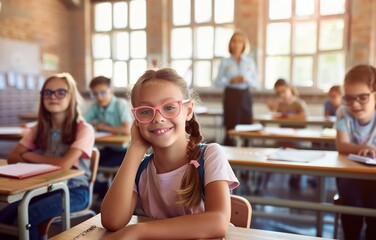 Portrait of a pretty girl with pink glasses in the background of a school classroom with other students