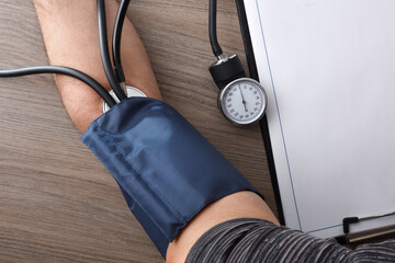 Taking blood pressure with a patient's arm with a tensiometer
