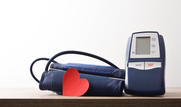 Blue digital blood pressure monitor on wooden table with hearth