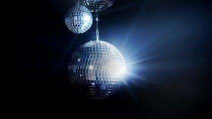 A close-up of a rotating disco ball casting dynamic light reflections on a black background. Ideal...