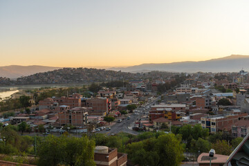 Obraz premium Panoramic view of the city of Cochabamba in Bolivia at sunset, surrounded by mountains.