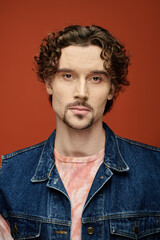 A thoughtful man showcases his emotions on a striking colorful background.