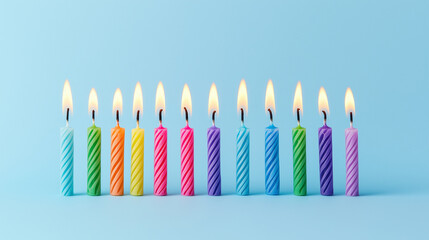 A row of colorful birthday candles lit against a blue background, symbolizing celebration and joy.