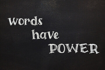 "Words have power" slogan written on black chalkboard