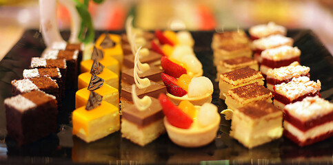 Beautiful multicolored decorated baked sweet tasty party cakes or catering cakes for party, bar dessert selection with cake, pie and pastries catering banquet, coffee break buffet at a conference