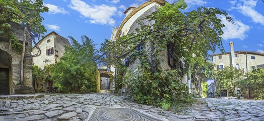 the old buildings and trees are covered in green vines on the cobblestone path
