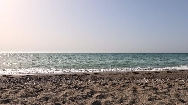 timelapse , c&aacute;mara r&aacute;pida, en la playa con el mar mediterr&aacute;neo en M&aacute;laga, con movimiento de peque&ntilde;as olas en la orilla y arena fina  y aviones que pasan por el cielo