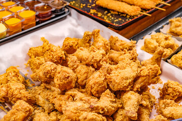 deep fried chicken legs in batter on street food market, selective focus