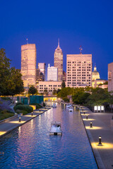 Indianapolis, Indiana skyline seen at night with buildings and canal walk in view. 