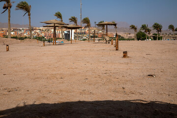 Old abandoned beach in sharm el sheikh. Sand and rusty beach umbrellas. Sunny day.