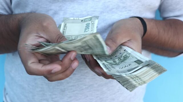 Man counting 500 Indian rupee banknotes