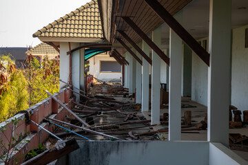 Corridor on the terrace of an old abandoned hotel. Shabby walls. Trees outside. A gloomy abandoned hotel.
