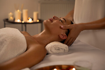 Masseuse making relaxing head massage for young lady, peaceful woman getting healing head massage...