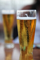 Two frosty beers with crisp, visible bubbles in clear glasses, capturing the refreshing essence of a perfect pour. Ideal for stock photography showcasing refreshing beverages.