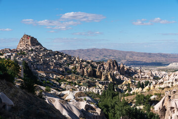 Evening view of Uchisar Castle in Cappadocia, Turkey, with ancient cave dwellings carved into the rugged landscape that stand as silent witnesses to centuries of history.