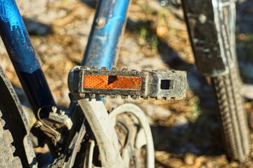 one plastic broken old with orange reflector black with iron lever foot pedal with blue frame and front wheel of sport bike daytime outdoors