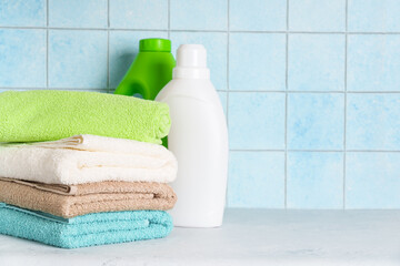 Clean towels and detergent in the laundry or bathroom against blue wall.