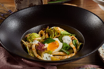 Fresh Squid Salad with Potato and Egg on Black Plate