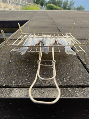Grilled shrimp, prawn skewer, european smelt fish and corn cobs on wooden cutting board at summer outdoor food market: close up. Barbecue, gastronomy, cookery, street food concept